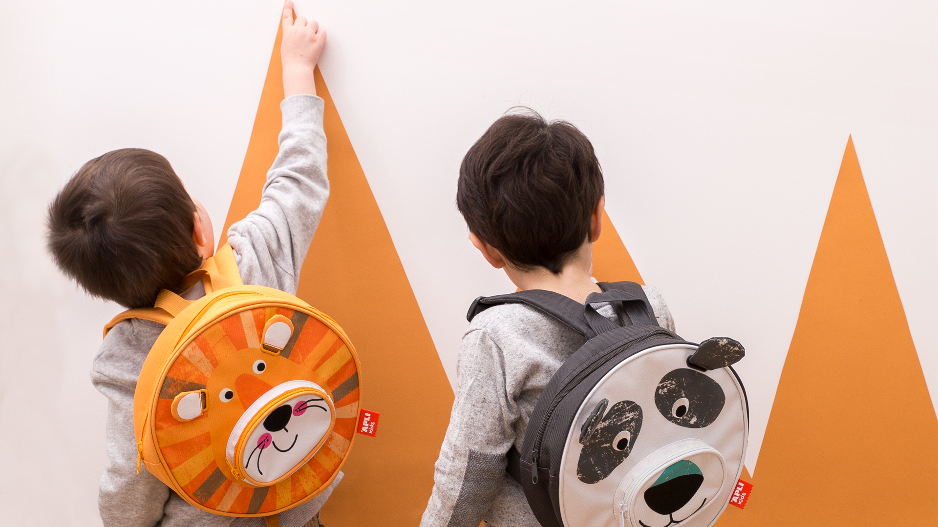 Niños con mochilas infantiles de Apli Kids con diseños de producto de Nomon Design, agencia de branding