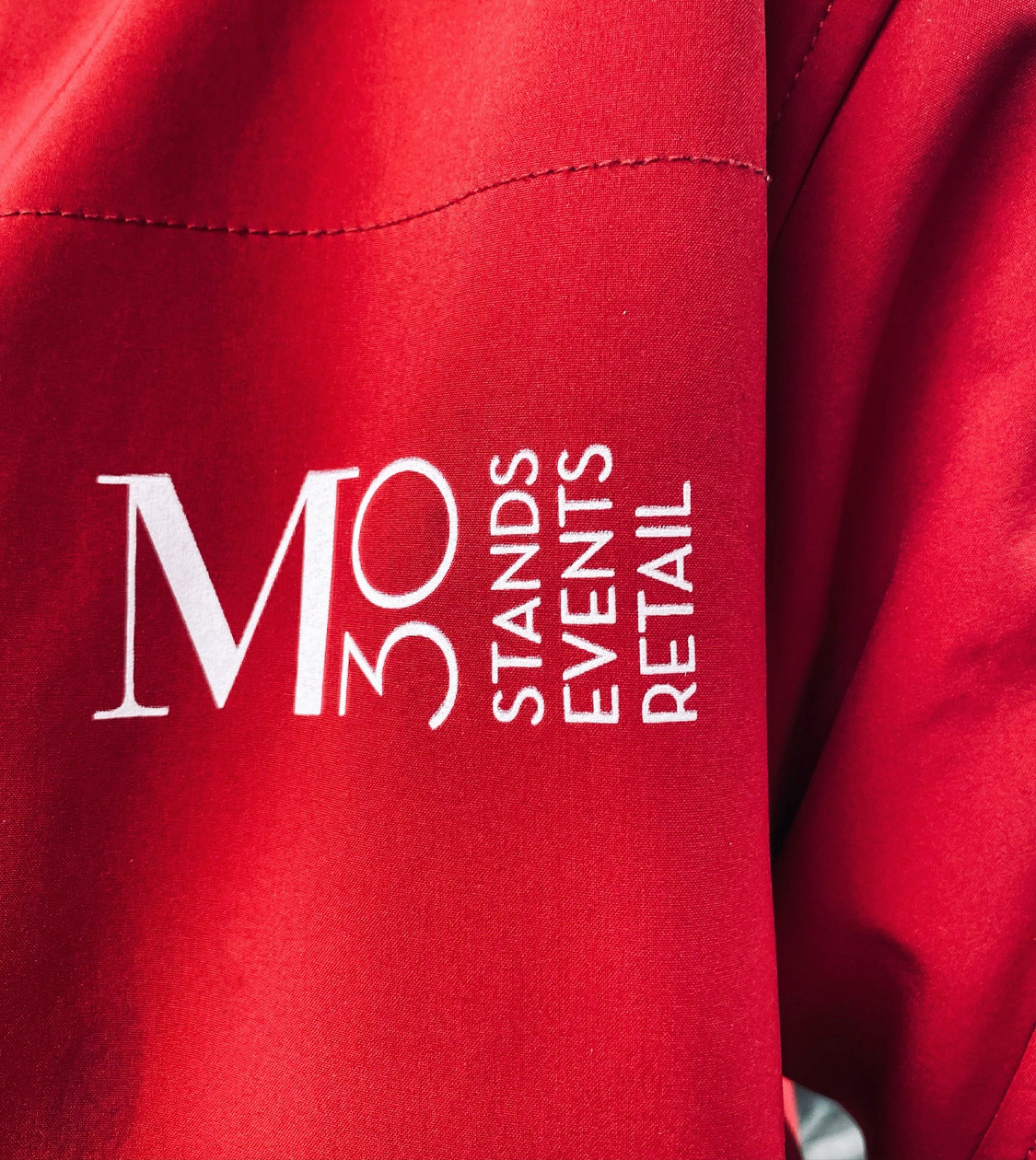 Aplicación del branding corporativo de M30 stands, events, retail en uniformidad por Nomon Design, agencia de branding