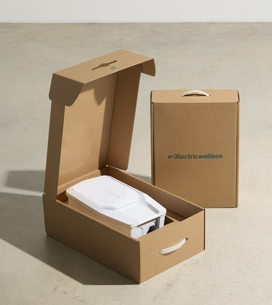Packaging de cartón abierto con cargador eléctrico e-3lectricwallbox en su interior, diseño de Nomon Design, agencia de branding, diseño gráfico y packaging de Barcelona.