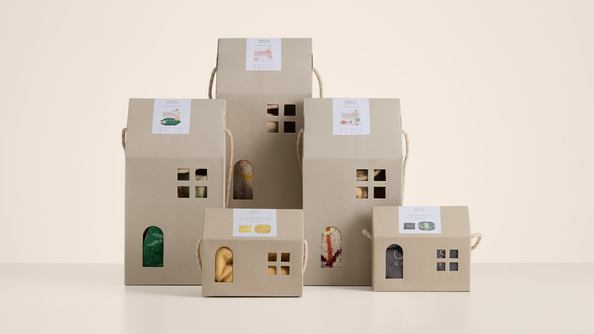 Diseño de packaging en forma de casitas para juguetes textiles de Lorena Canals, diseñadas por Nomon Design, agencia de branding