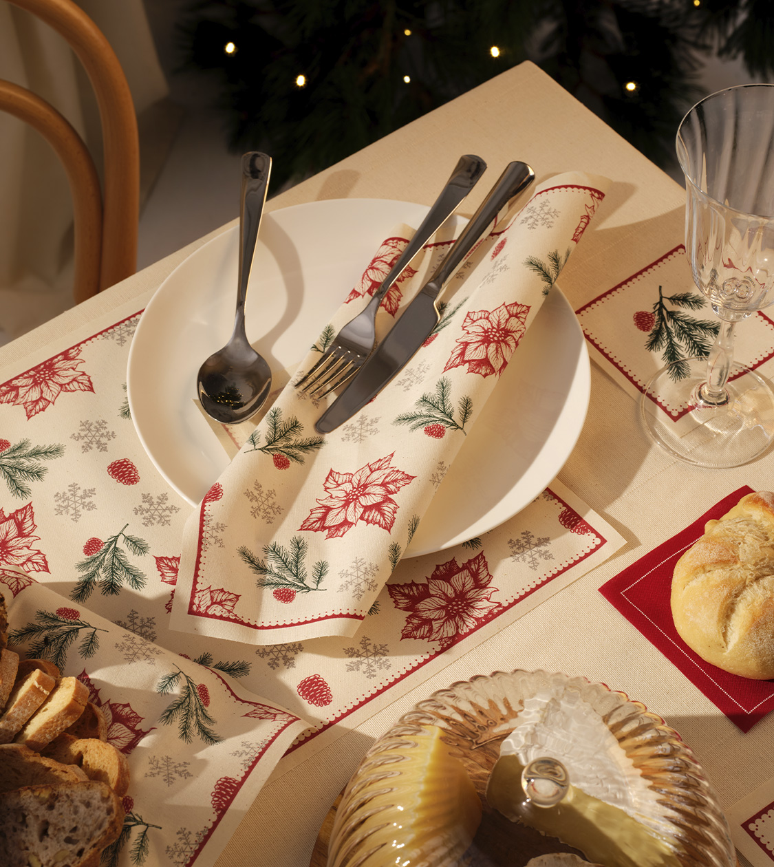 Vista cenital de la colección Botanic de MY DRAP por Nomon Design, con individuales y servilletas a juego, en una mesa navideña decorada con pan, copas y velas.